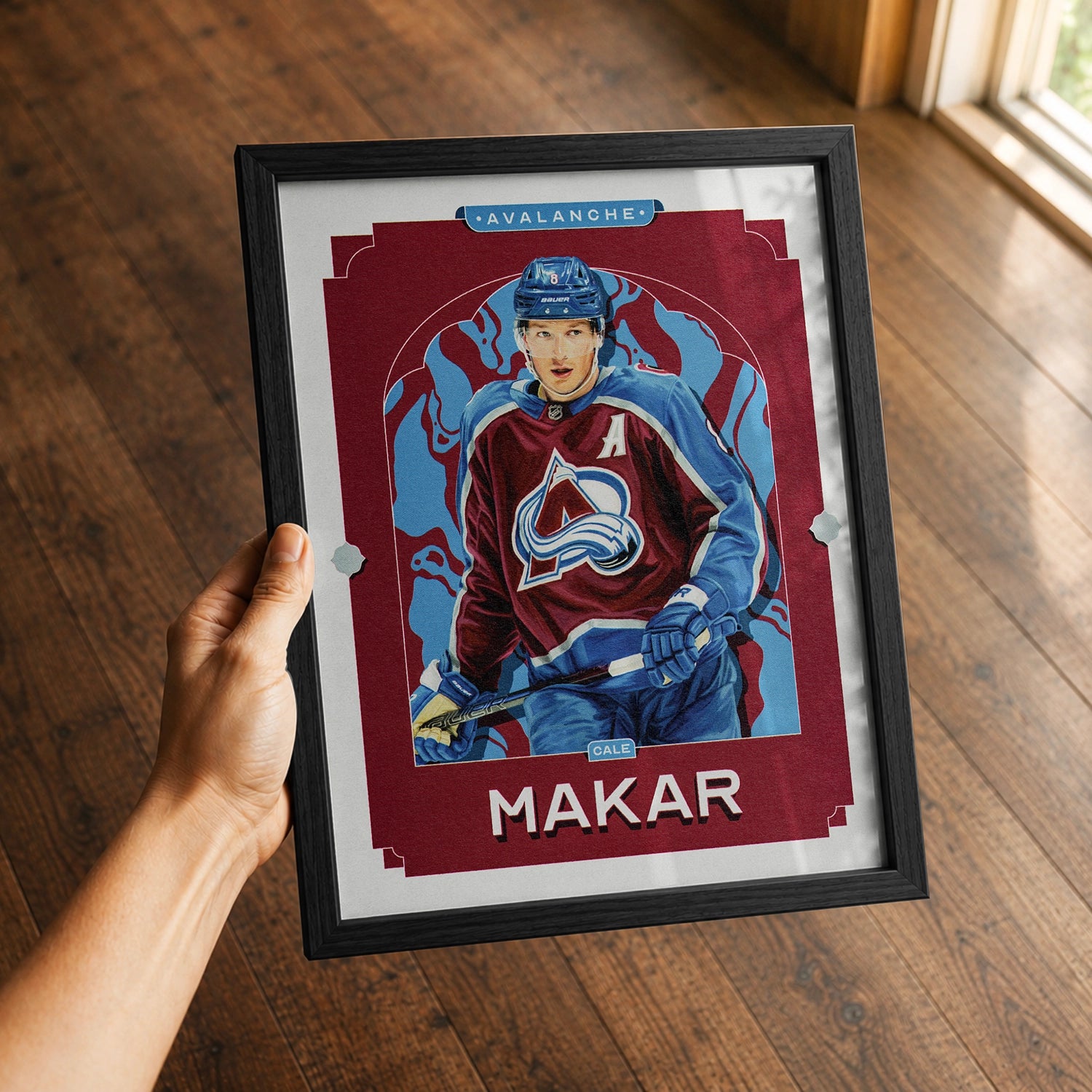 A premium Cale Makar poster in a 8x10 frame being gifted to a Colorado Avalanche fan.